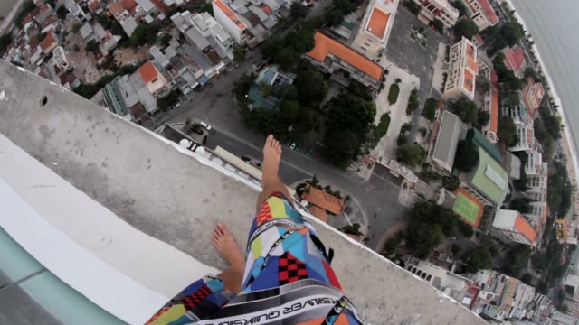 Man Standing On The Edge Of A Tall Building