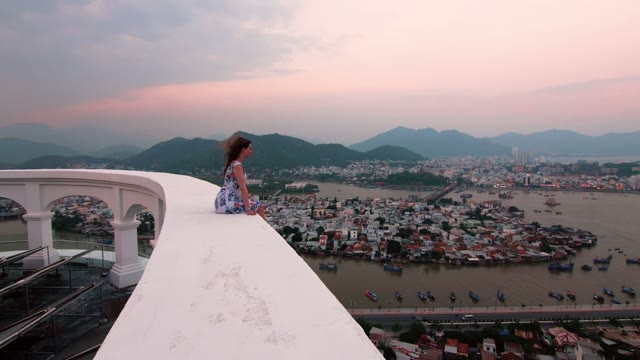 Girl Sitting On A Background Of Mountains And Sea