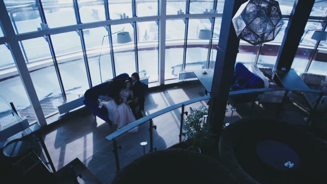 The Bride And Groom Lying On A Sofa In The Elegant Interior