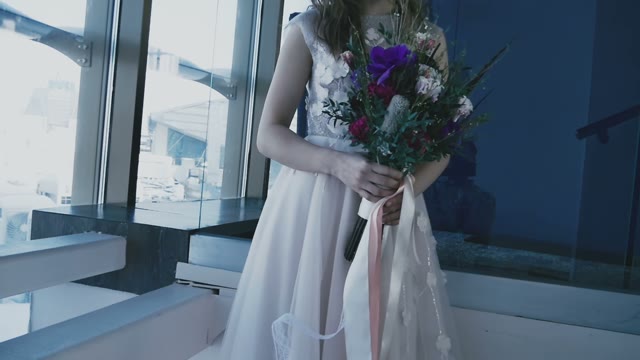 The Bride In Beautiful Dress Is Rotated By The Window