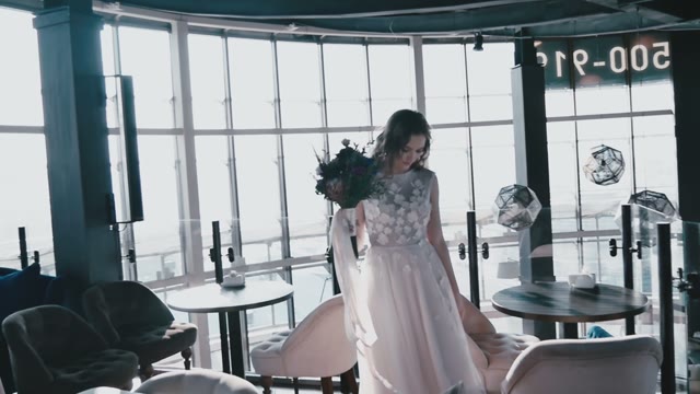 Bride Holding Flowers Is Spinning In Dance In The Interior Of A Nice Cafe