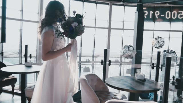 Bride With Flowers In Her Hands Against The Backdrop Of Panoramic Windows