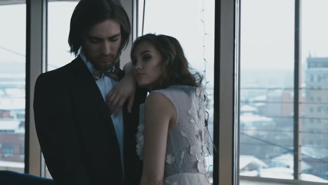 The Bride And Groom Embrace Near The Window