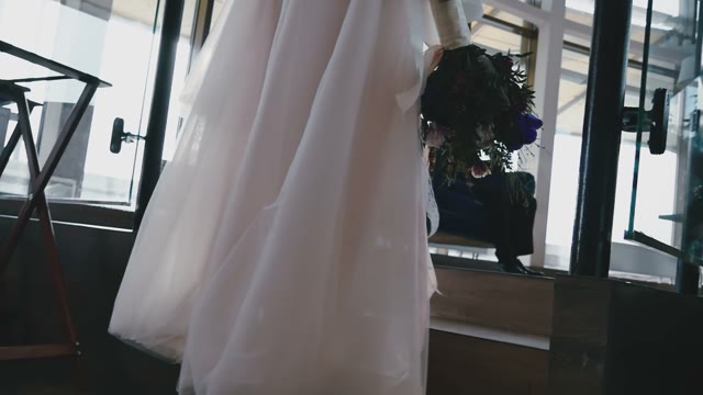 The Bride With A Bouquet Of Flowers Goes Up The Stairs To Meet The Bridegroom