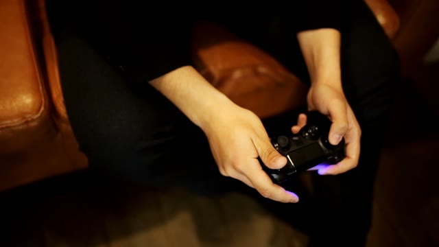 Hands Of Men Play On The Joystick To The Console