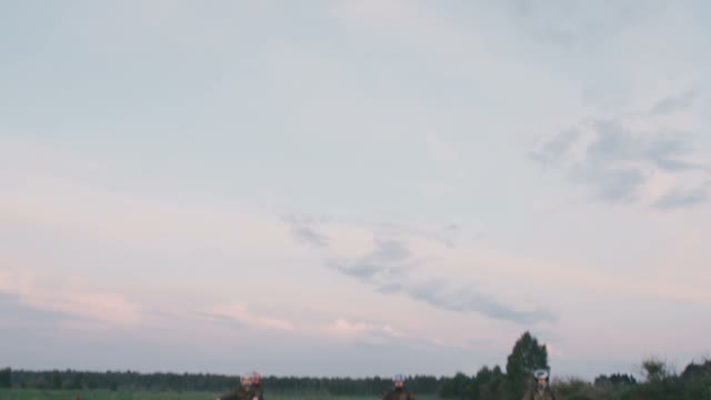 The Guys On Quad Bikes Ride Through The Green Grass