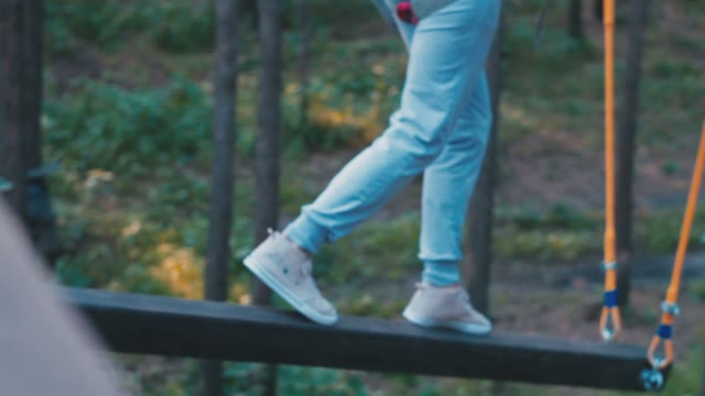 The Girl Walking On The Pieces Of Wood Hanging On A Rope