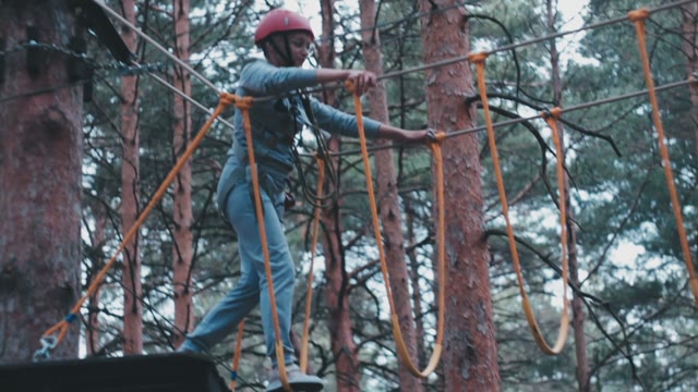 The Girl Tightrope Walker Overcomes Suspended Obstacles