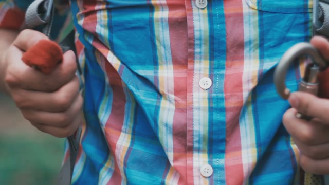 Tightrope Walker In A Plaid Shirt Clings To The Rope Carabiner