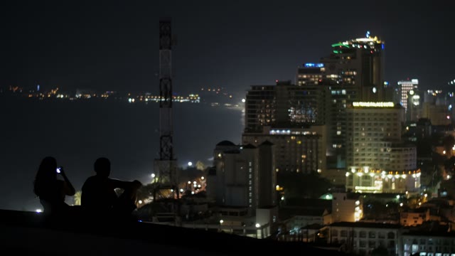 Man And Woman Sitting On The Roof Of The Building