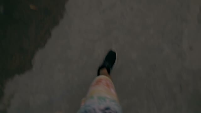 Men's Feet Walking Along The Road