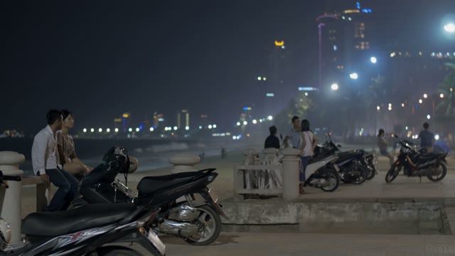 People Sit Near Mopeds