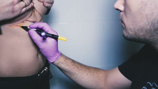 A Young Tattoo Artist Delineates The Area On Which Will Be Tattooed On The Body