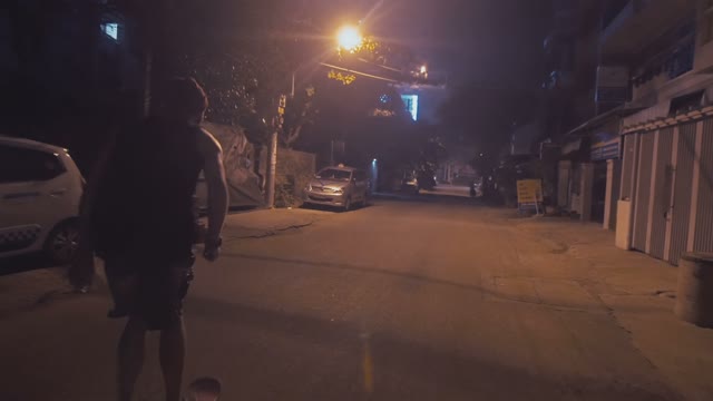 Man Riding A Skateboard On The Road At Night