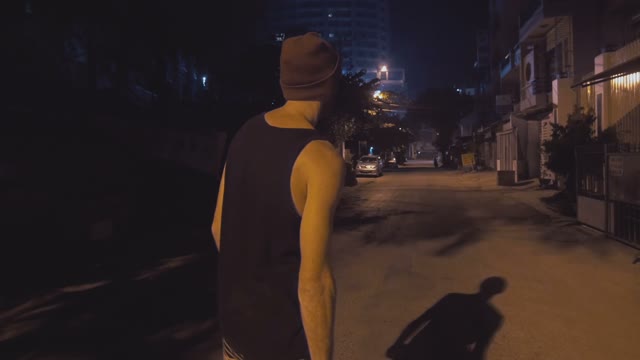Man Riding On A Skateboard On The Road At Night