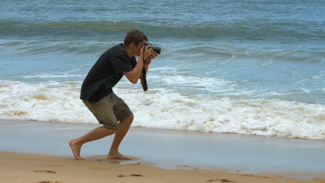 Photographer At Work On The Background Of The Raging Ocean Waves