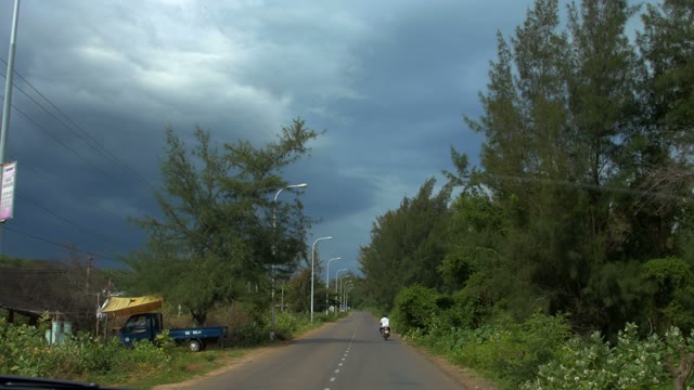 Among Woods On A Small Paved Road Passes Through A Man