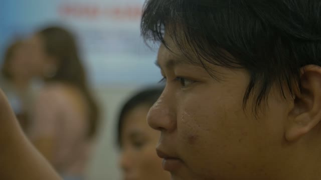 Asian Boy Engaged Sawing Wooden Souvenirs