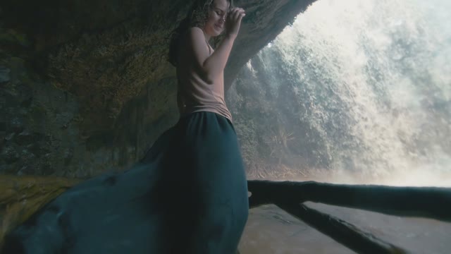 Girl With A Flying Skirt Behind A Waterfall