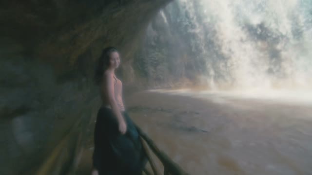 Girl Poses A Face Behind The Waterfall