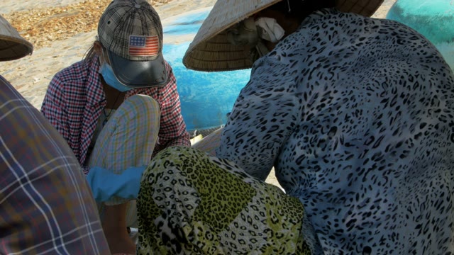 Asian Woman Wearing Masks And Headdresses Busy With Fish