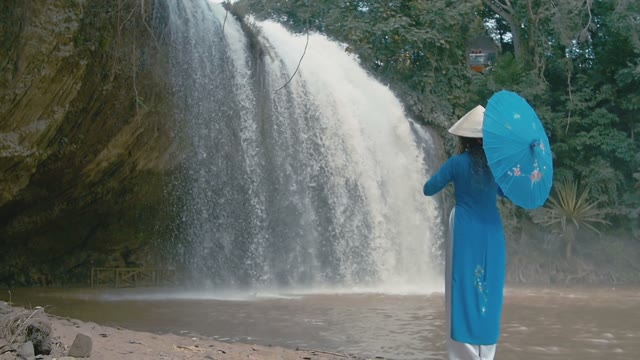 Girl With Umbrella On The Background Of A Waterfall