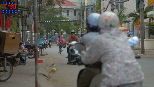 A Couple Of People On A Motorcycle Crossing A City Street