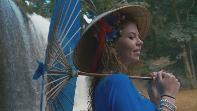 Girl With Umbrella On The Background Of A Waterfall Close-up
