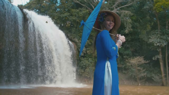 Girl With Umbrella On The Background Of A Waterfall