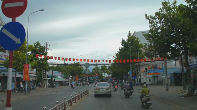 Flags Over The Road With Traffic Signs And Lots Of Cars Motorcycles