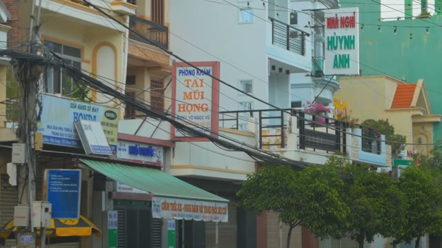 View Of The Balconies Of Houses And Shop Signs Of A Passing Car