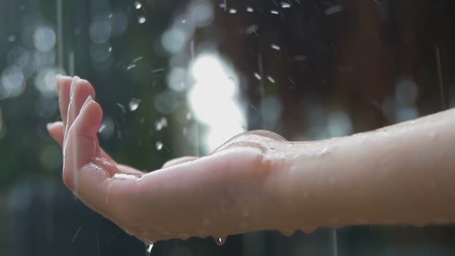 Women's Hand Covered In Droplets Of Heavy Rain