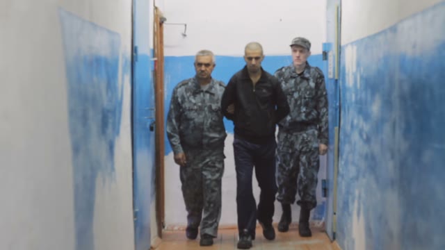 Suspected Criminal Held Along The Corridor Under The Supervision Of Two