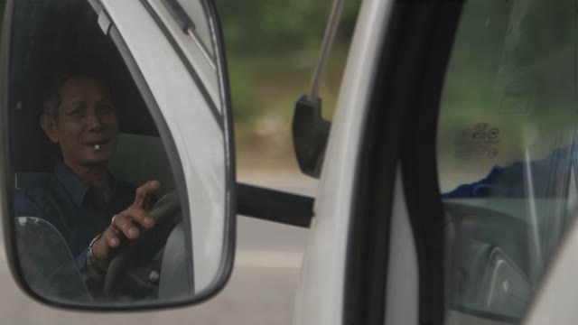 Reflection Of The Driver In A Car Mirror