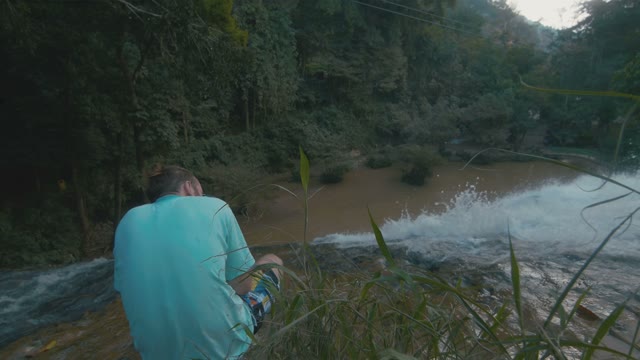 Man Takes A Picture Of A Waterfall