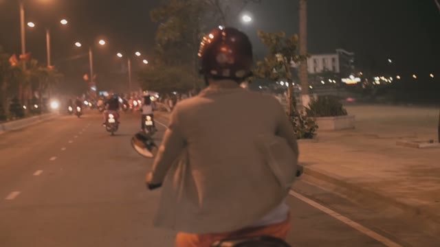 People On Mopeds Ride On The Road