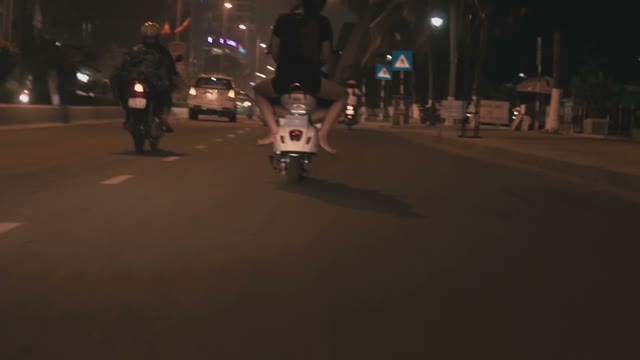 People On Mopeds Ride On The Road