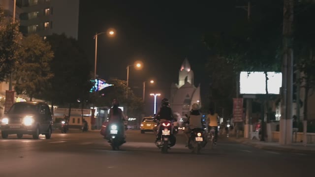 People On Mopeds Ride On The Road