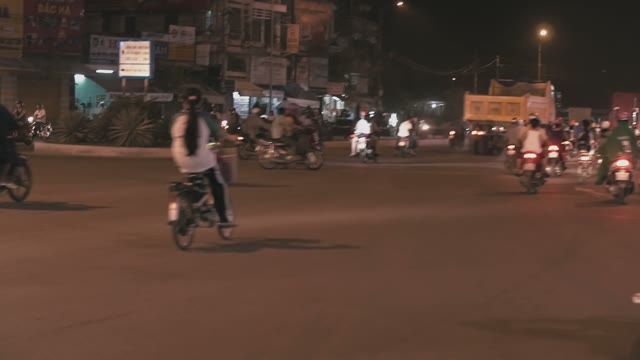 People On Mopeds Ride On The Road