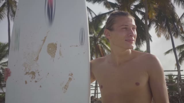 Young Attractive Surfer Is Standing On The Beach
