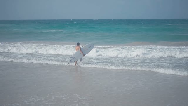 Young Surfer Enters The Water