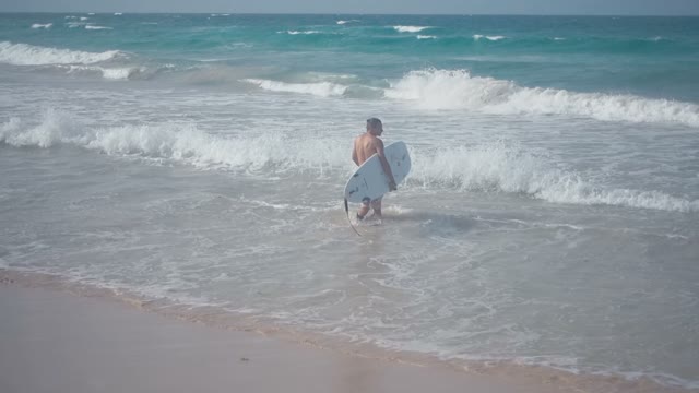 The Surfer Goes Into The Water