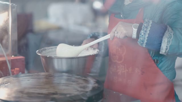A Woman Prepares A Pancake On A Large Round Plate