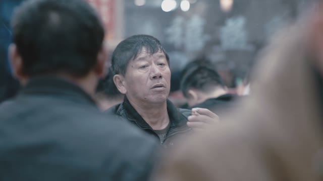 Chinese Man Sitting In A Cafe And Smoking A Cigarette