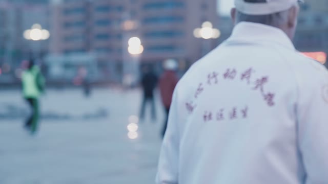 Adult Man In A White Tracksuit With Chinese Characters On The Back