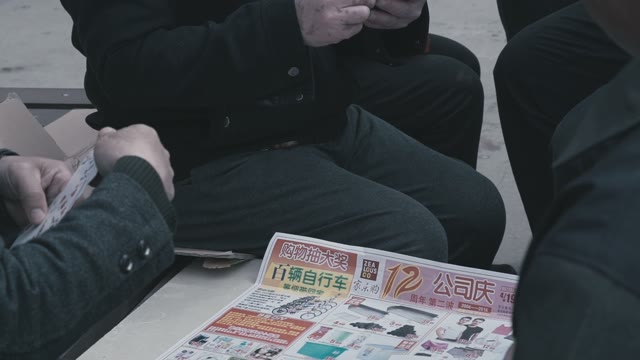 Chinese Men Playing Cards In The Local Newspaper