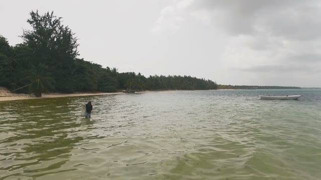 A Man Is Fishing In The Sea With A Net