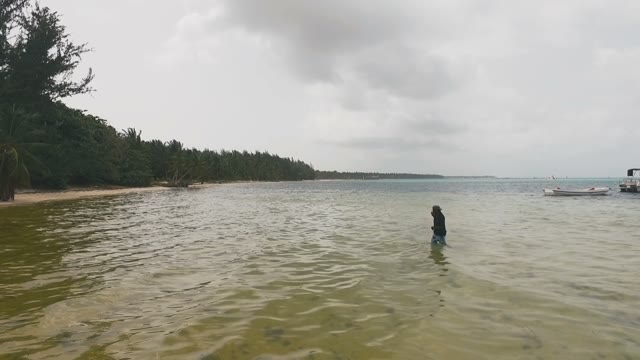 A Black Man Comes Out Of The Water With A Net Full Of Fish