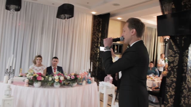 Man Speaks Into A Microphone And Takes Pictures On A Smartphone