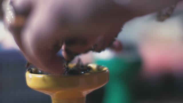 Man Puts Tobacco In A Hookah Close-up